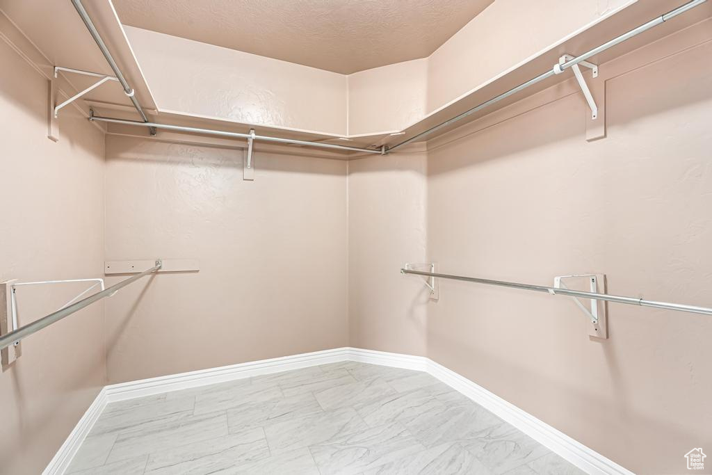 Spacious closet featuring marble finish floors