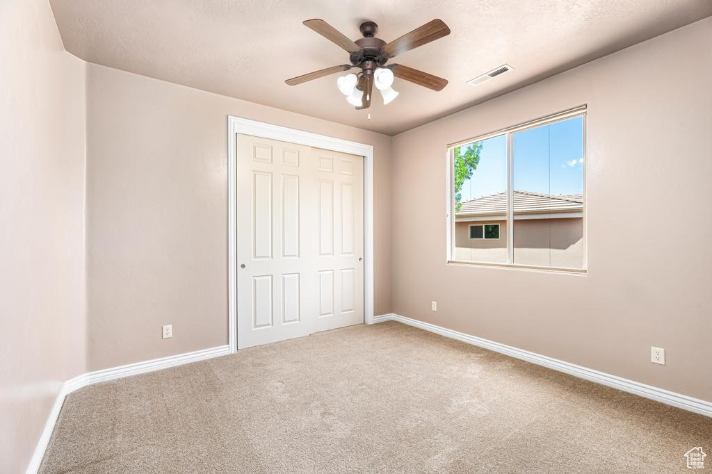 Unfurnished bedroom featuring carpet floors, baseboards, and a closet