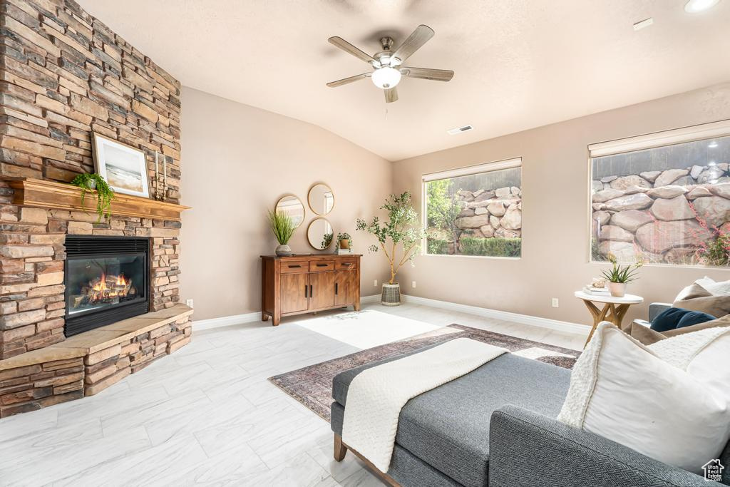 Bedroom with lofted ceiling, a stone fireplace, ceiling fan, and baseboards