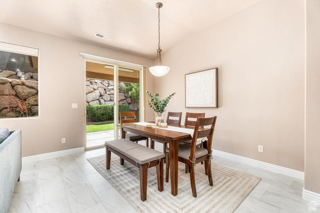 Dining area featuring light marble finish floors and baseboards