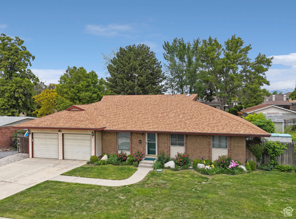 Ranch-style house with concrete driveway, a garage, roof with shingles, and brick siding
