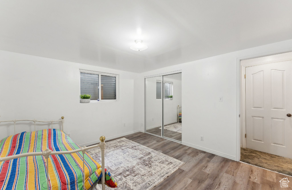 Bedroom featuring wood finished floors, a closet, and baseboards