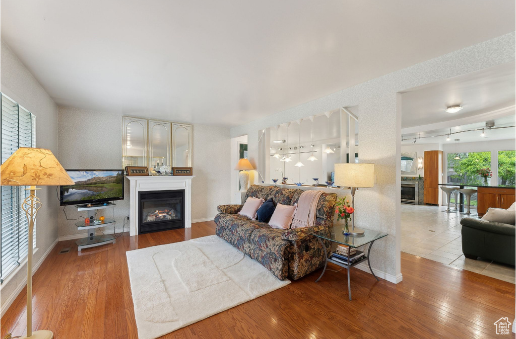 Living room featuring a glass covered fireplace, wood finished floors, and baseboards
