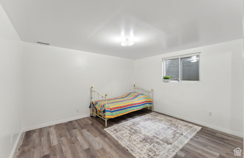 Bedroom featuring wood finished floors and baseboards