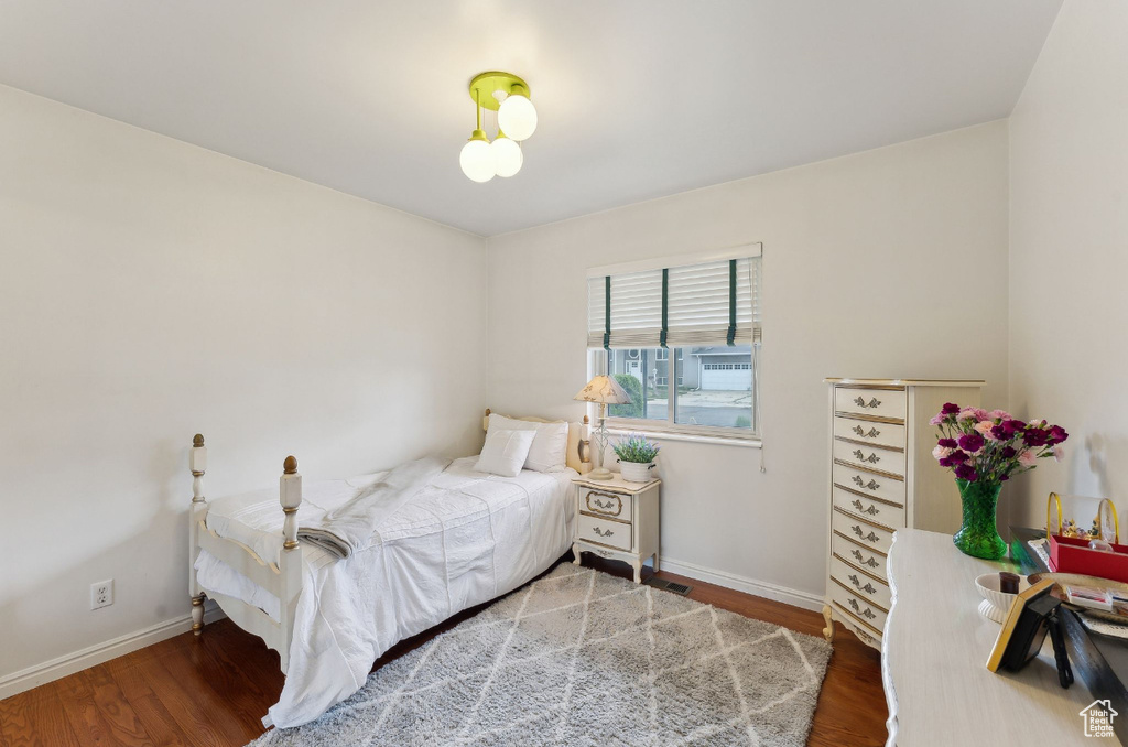 Bedroom with wood finished floors and baseboards