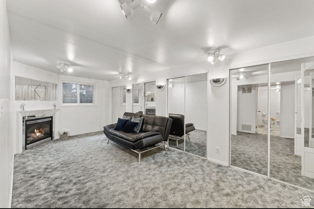 Carpeted living area featuring a glass covered fireplace