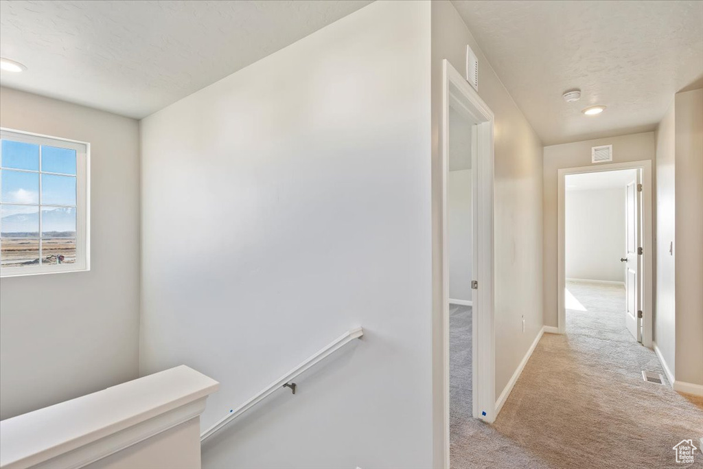 Corridor with light colored carpet, baseboards, an upstairs landing, and recessed lighting