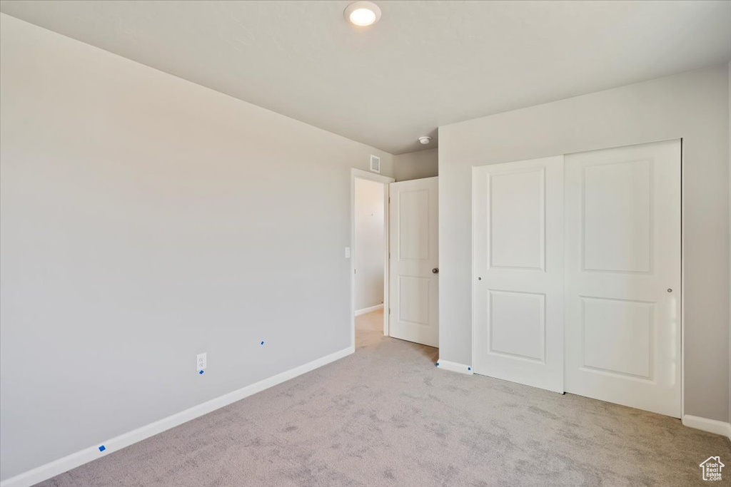 Unfurnished bedroom featuring carpet, baseboards, and a closet