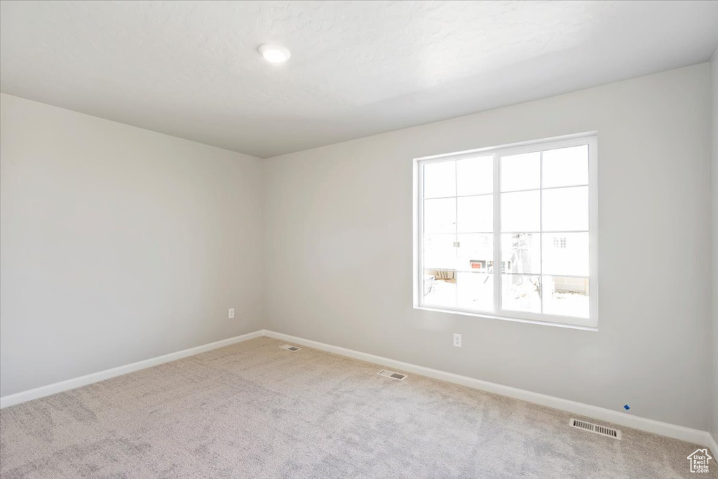 Carpeted spare room with baseboards