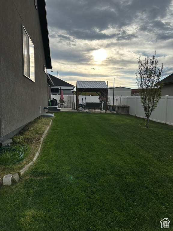 Yard at dusk featuring a patio area