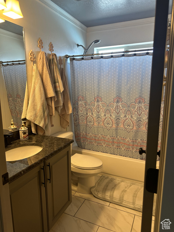 Full bath featuring vanity, shower / bath combo with shower curtain, toilet, marble finish floors, and crown molding