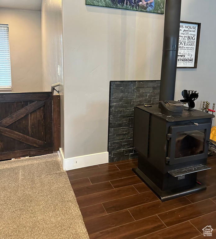 Interior details featuring dark hardwood / wood-style floors and a wood stove