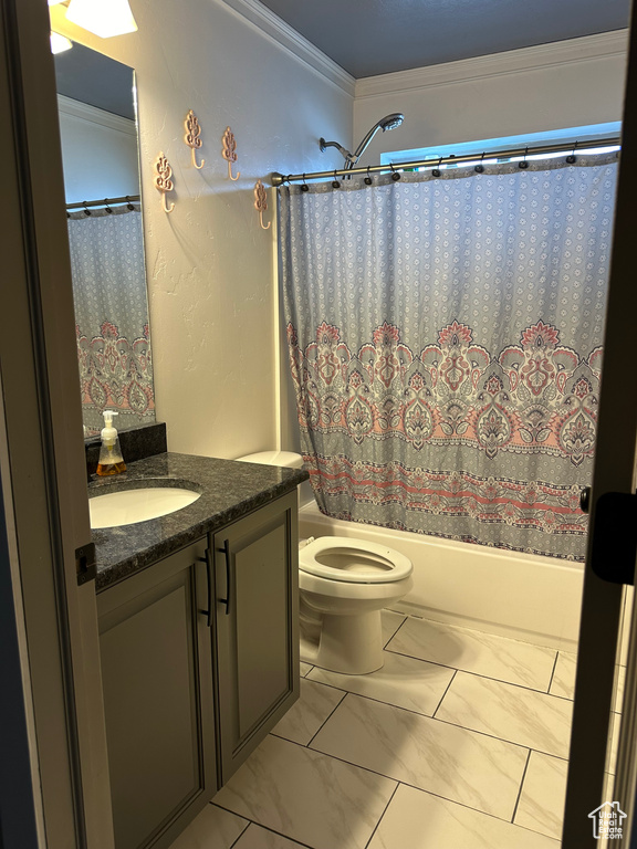 Full bathroom with crown molding, tile flooring, shower / bath combo with shower curtain, oversized vanity, and toilet