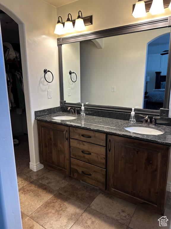 Bathroom featuring dual bowl vanity and tile flooring