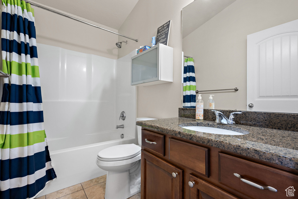 Full bathroom with tile patterned floors, vanity, shower / bath combo with shower curtain, and toilet