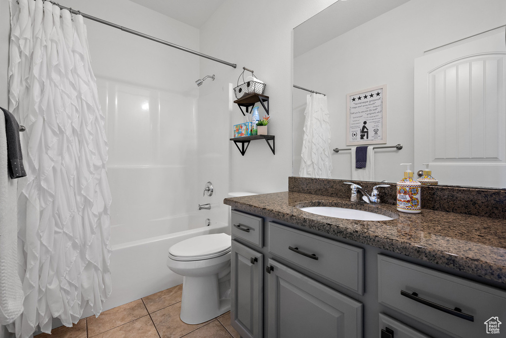 Bathroom featuring tile patterned floors, vanity, shower / bath combo, and toilet