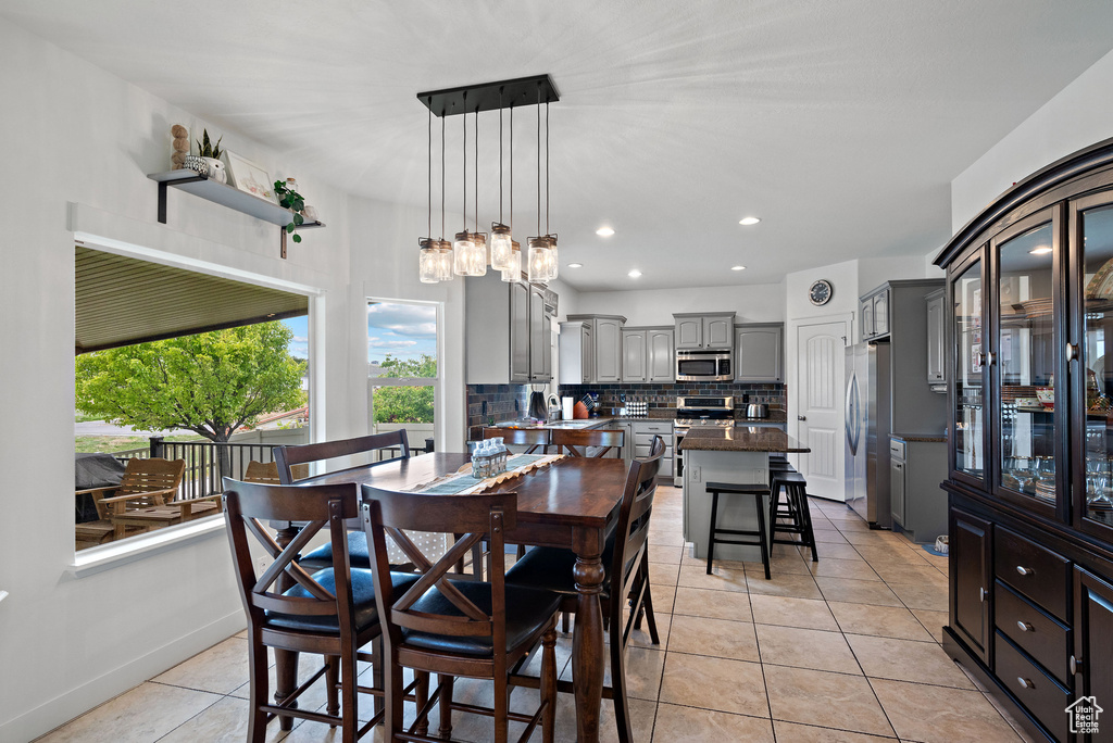 Dining space featuring light tile patterned flooring, recessed lighting, and a chandelier