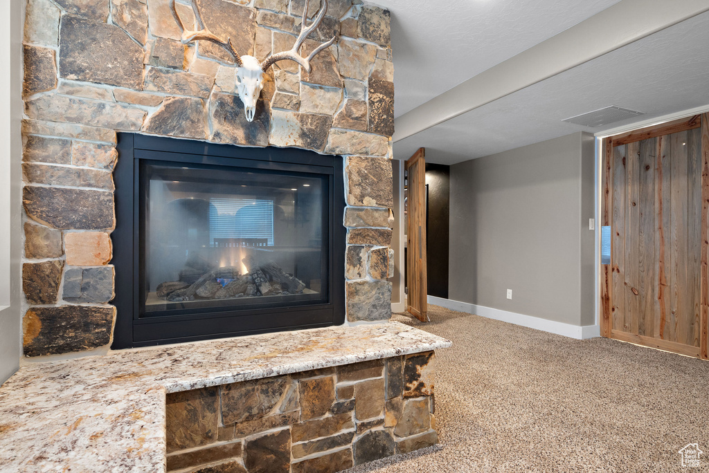 Detailed view of baseboards, carpet floors, and a fireplace