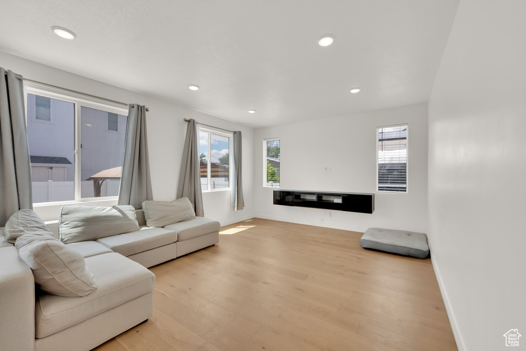 Living area with light wood-style flooring, recessed lighting, and baseboards