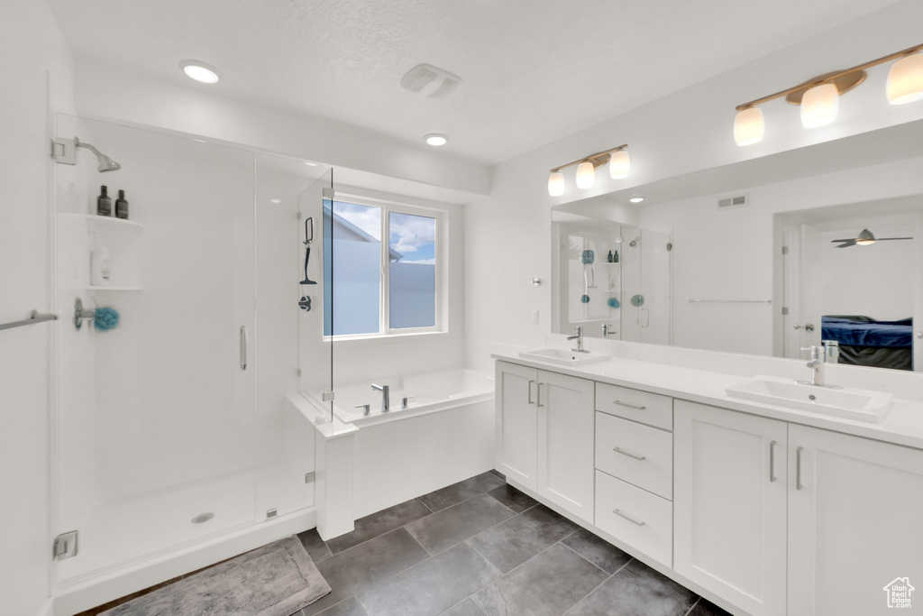 Full bathroom with a shower stall, a bath, double vanity, ensuite bathroom, and ceiling fan