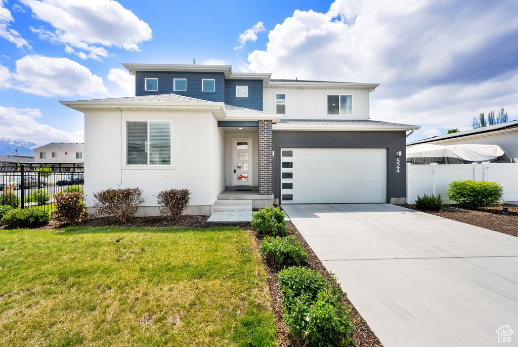 Prairie-style home with concrete driveway, a garage, and stucco siding