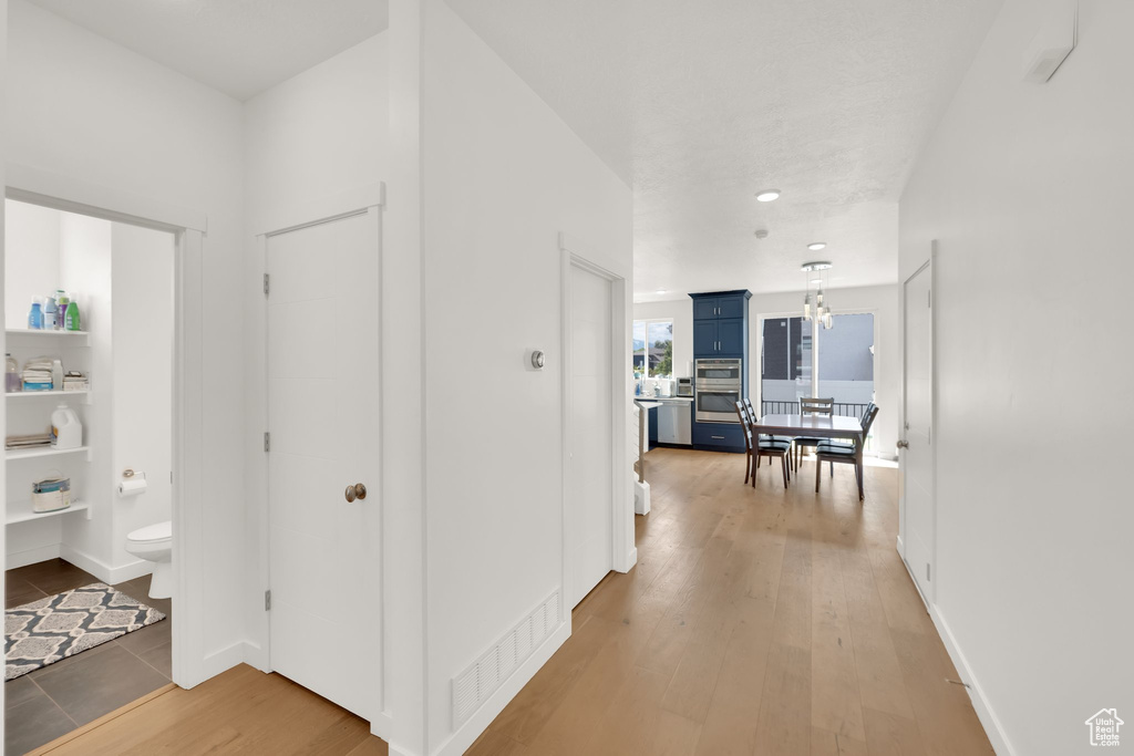 Hallway featuring light wood-style floors, recessed lighting, and baseboards