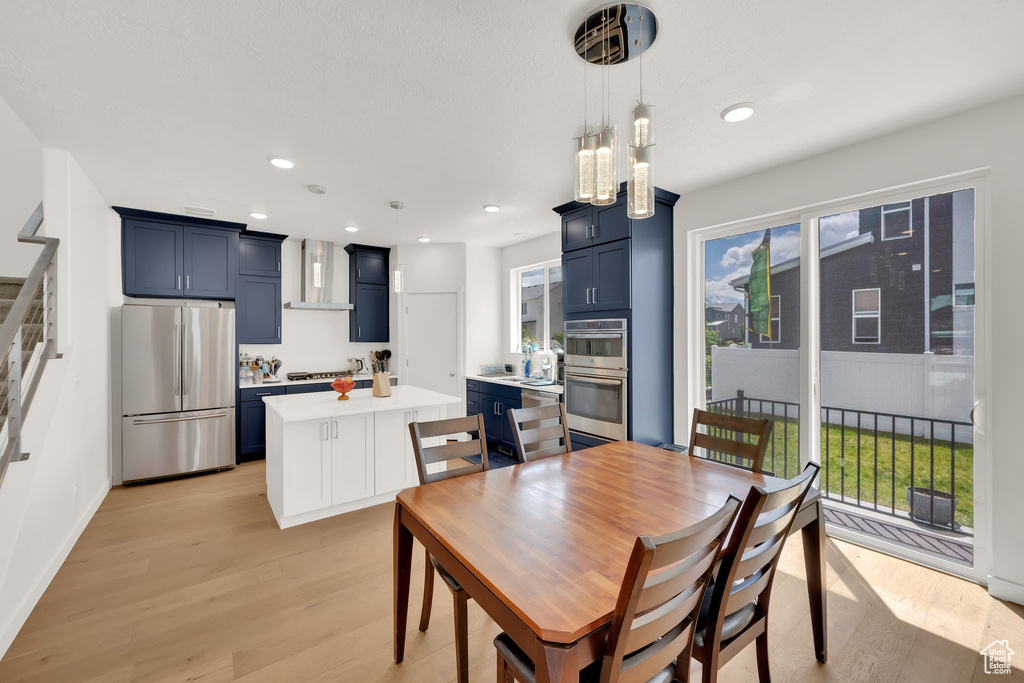 Dining room with light wood-style flooring, recessed lighting, and baseboards