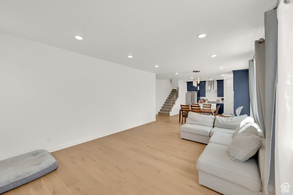 Living area with light wood-type flooring, recessed lighting, baseboards, and stairs