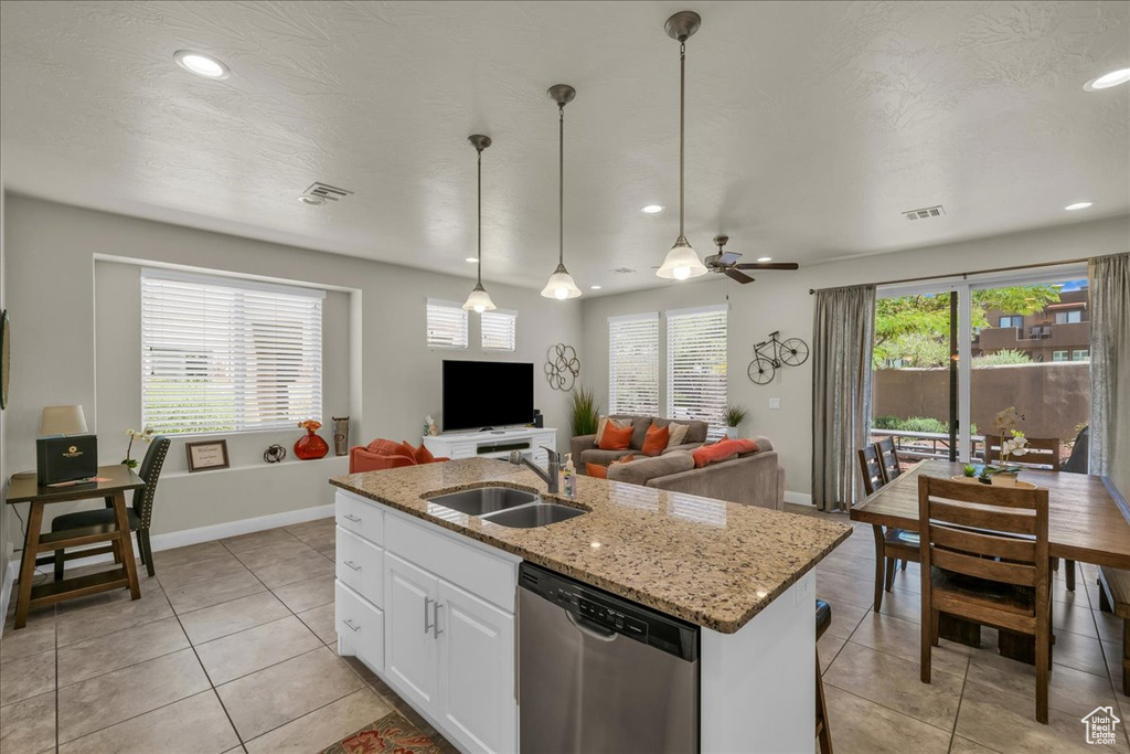 Kitchen with stainless steel dishwasher, a sink, light tile patterned flooring, baseboards, and recessed lighting