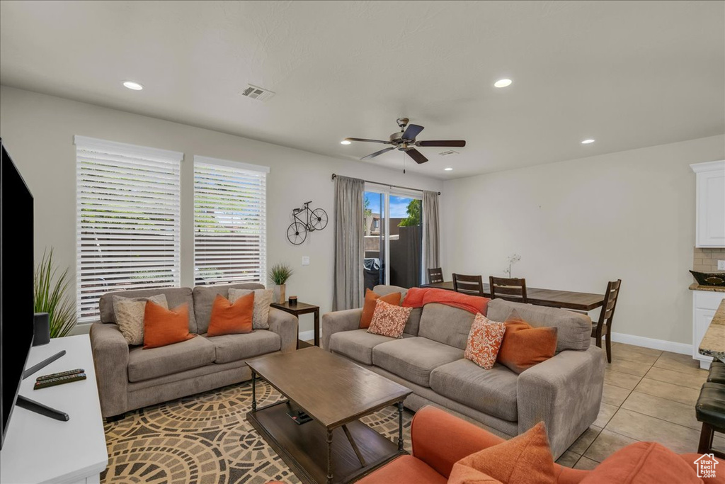 Living area with recessed lighting, a ceiling fan, light tile patterned floors, and baseboards