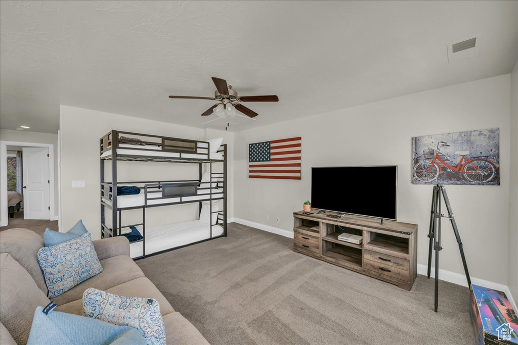Living room with carpet floors, ceiling fan, and baseboards