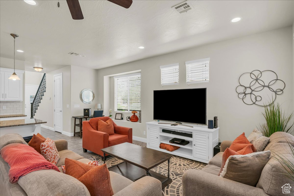 Living area with stairs, a ceiling fan, recessed lighting, baseboards, and light tile patterned flooring