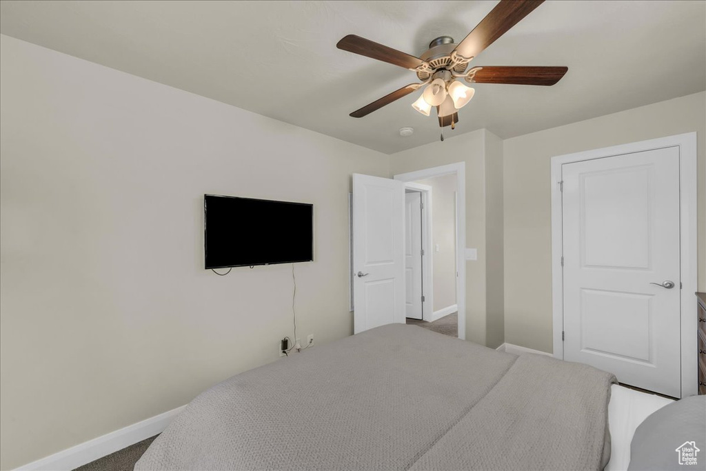 Carpeted bedroom with baseboards and ceiling fan