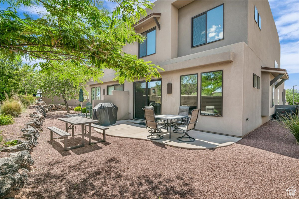 Back of house with stucco siding and a patio area