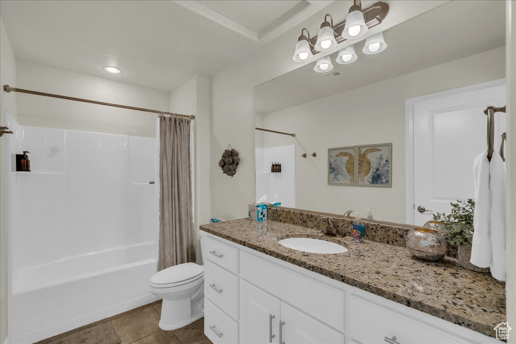 Bathroom with toilet, shower / tub combo with curtain, vanity, and tile patterned flooring