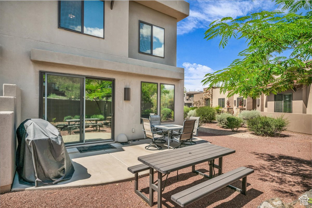 Rear view of property with stucco siding, outdoor dining area, and a patio area