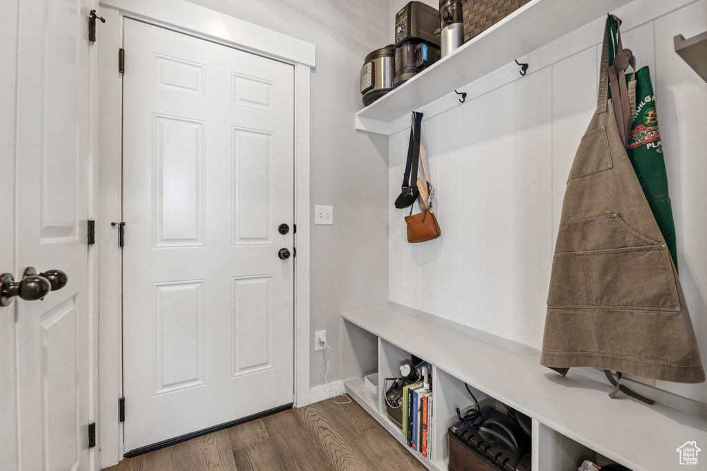 Mudroom featuring dark wood-style floors and baseboards