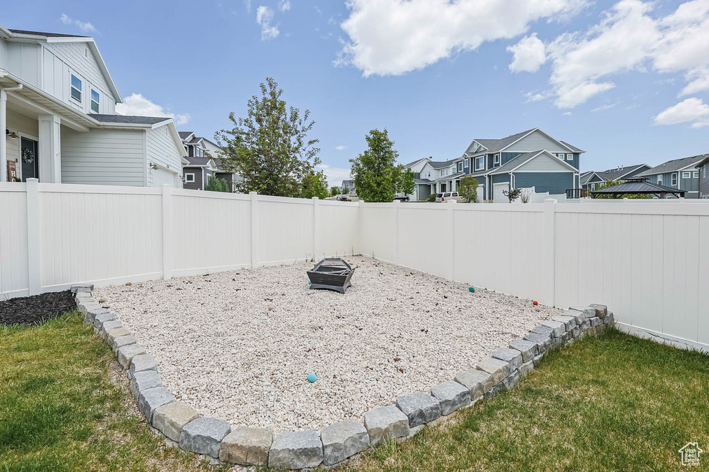 Fenced backyard with a residential view and an outdoor fire pit