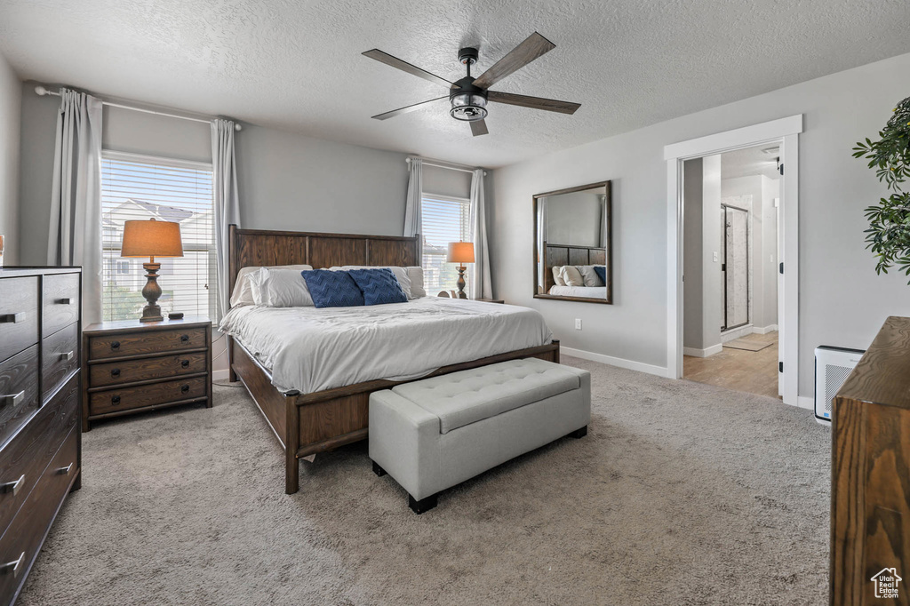 Carpeted bedroom featuring a textured ceiling and a ceiling fan