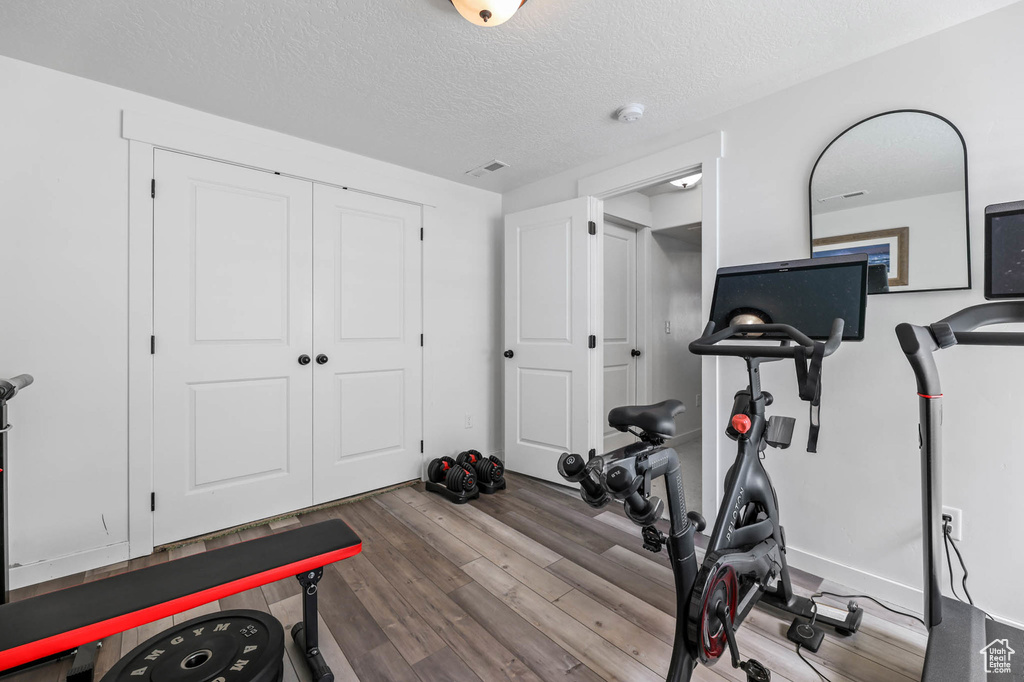Workout room featuring wood finished floors and a textured ceiling