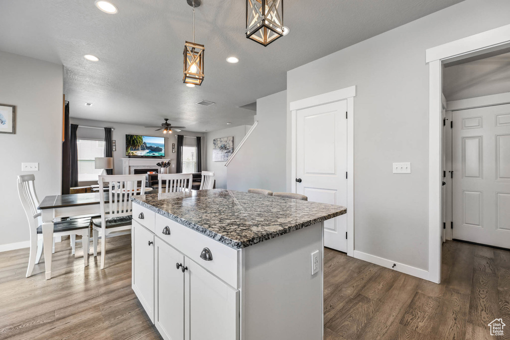 Kitchen with a kitchen island, ceiling fan, dark wood finished floors, recessed lighting, and white cabinets
