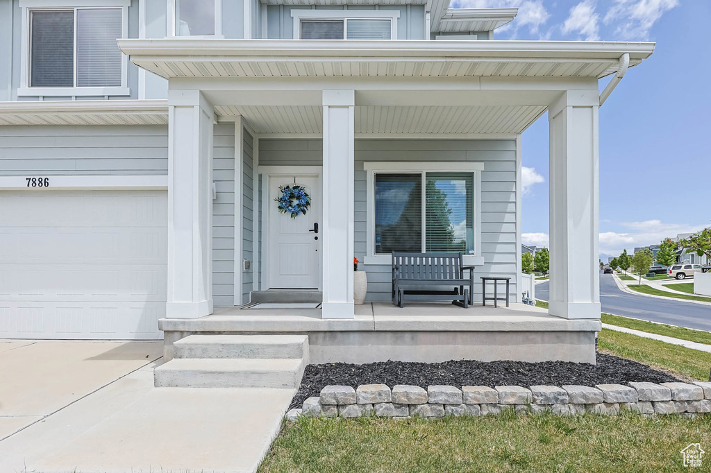 Doorway to property featuring covered porch and an attached garage