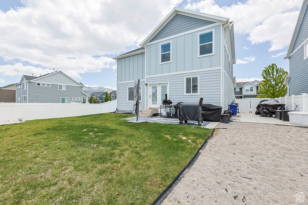 Rear view of house with board and batten siding, a patio, and entry steps