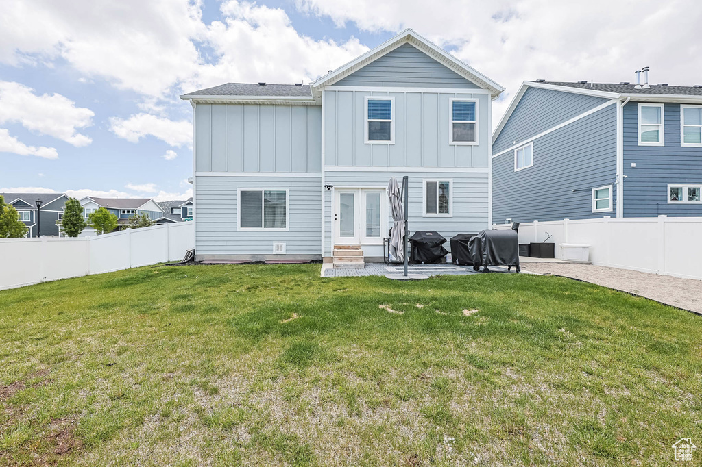 Back of property featuring board and batten siding, entry steps, a patio area, and french doors