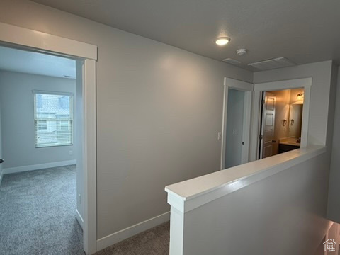 Corridor featuring carpet floors, an upstairs landing, and baseboards