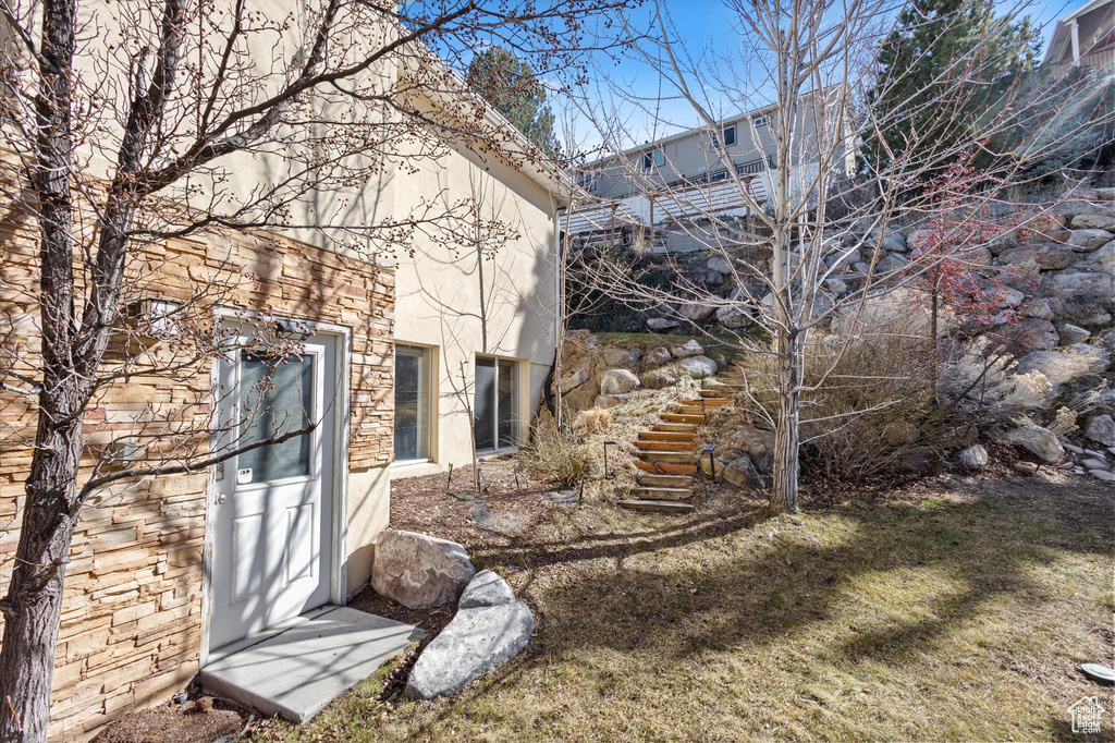 View of side of property with stucco siding and stairs