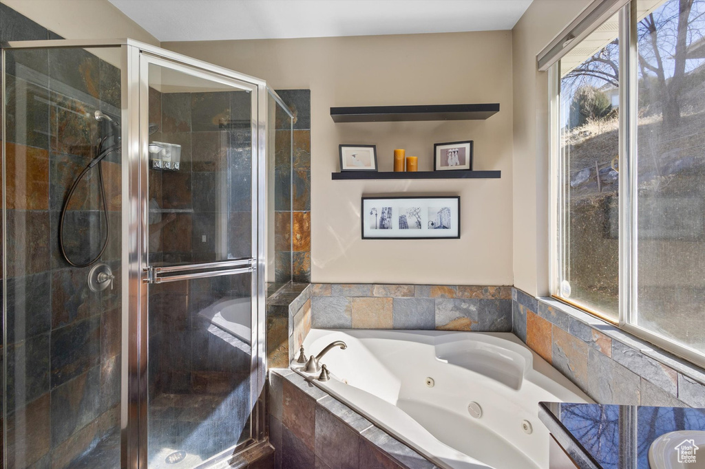 Bathroom with a shower stall and a jetted tub