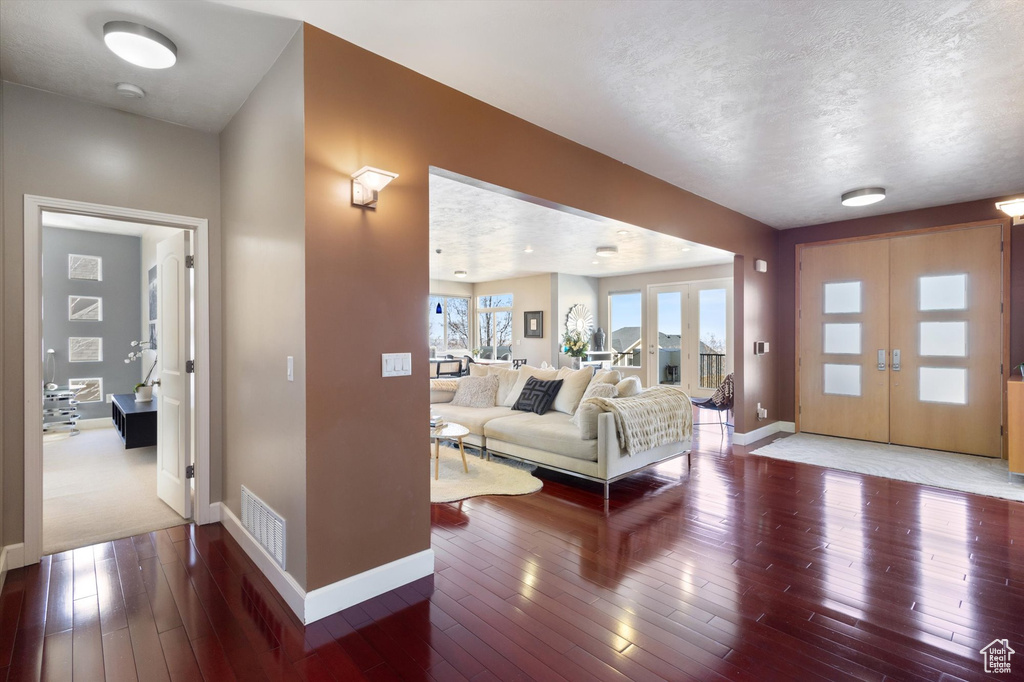 Living area featuring baseboards, wood-type flooring, and a textured ceiling