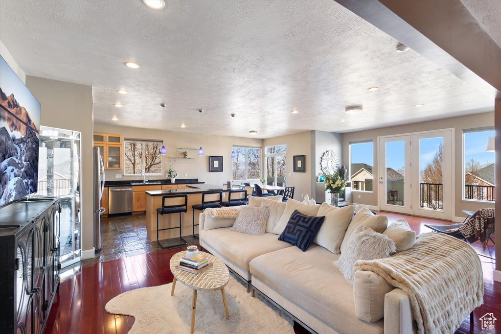 Living area featuring recessed lighting, dark wood-type flooring, a textured ceiling, and baseboards