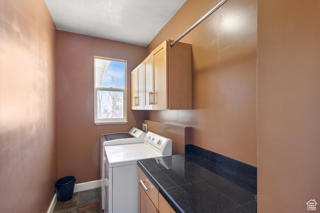 Laundry room featuring cabinet space, washing machine and clothes dryer, and baseboards